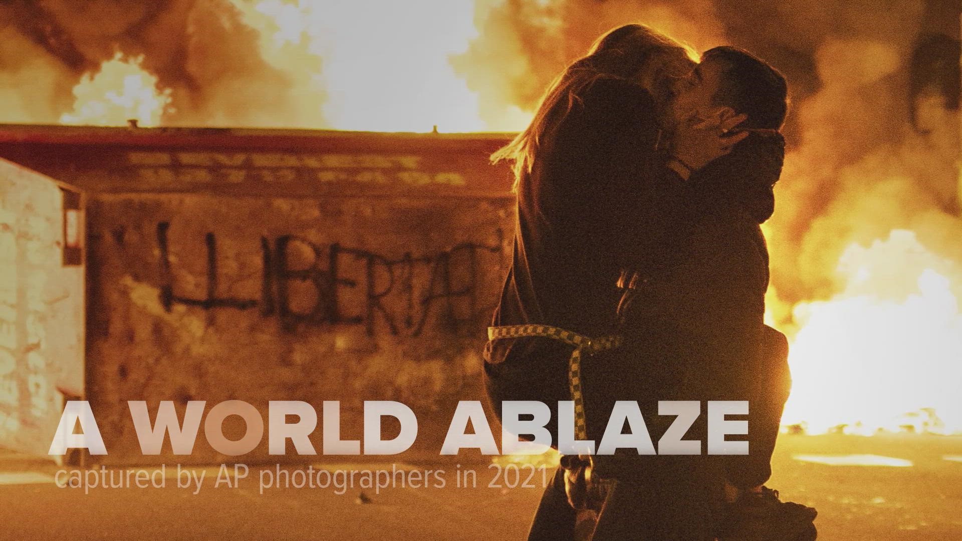 Associated Press photographers captured scenes of a world ablaze in 2021, amid rumblings of ruin.
