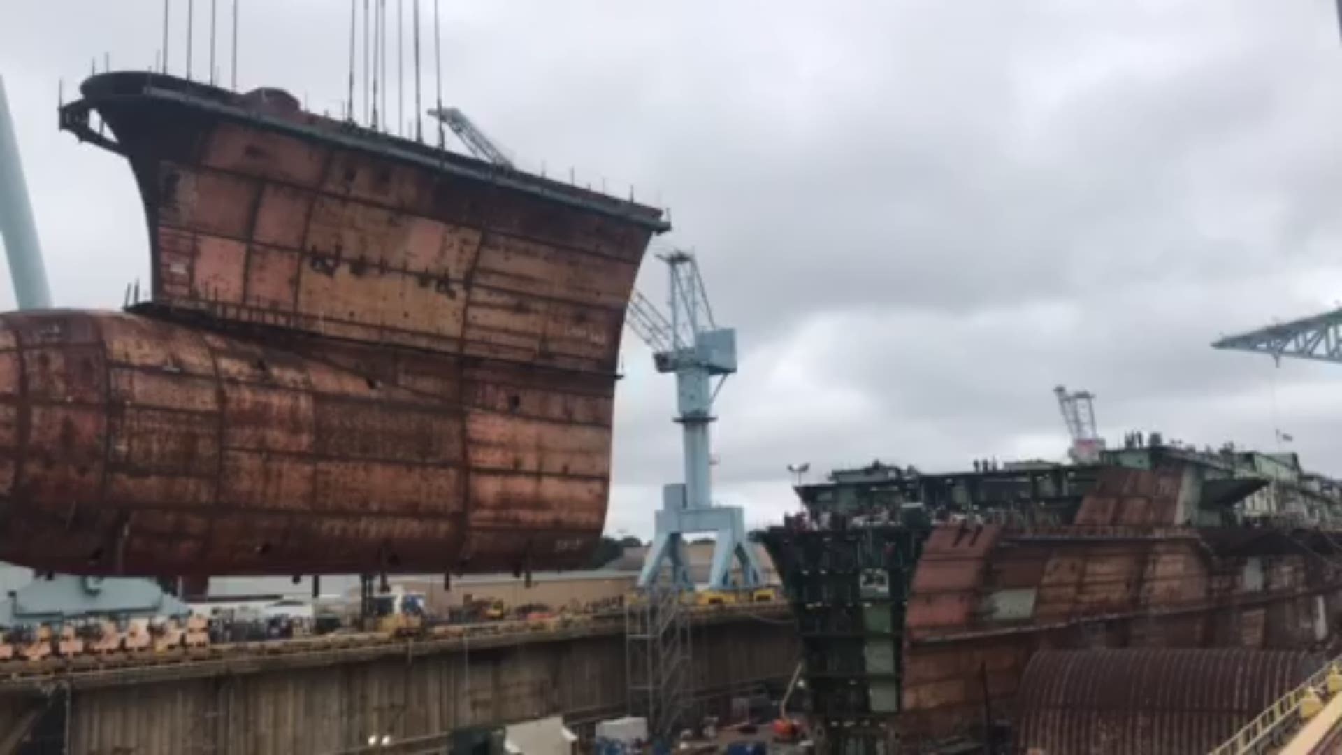 The final keel section of the future USS John F. Kennedy aircraft carrier is lowered into place at Newport News Shipbuilding.