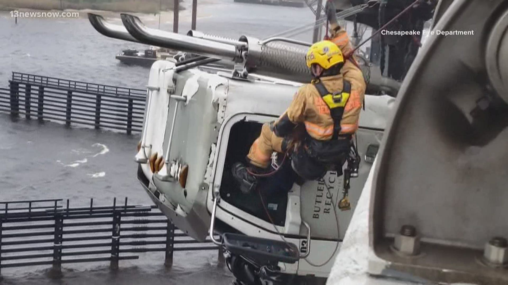 New video shows the dramatic rescue of a truck driver dangling over the Elizabeth River. A Chesapeake firefighter battled strong winds to save the man.