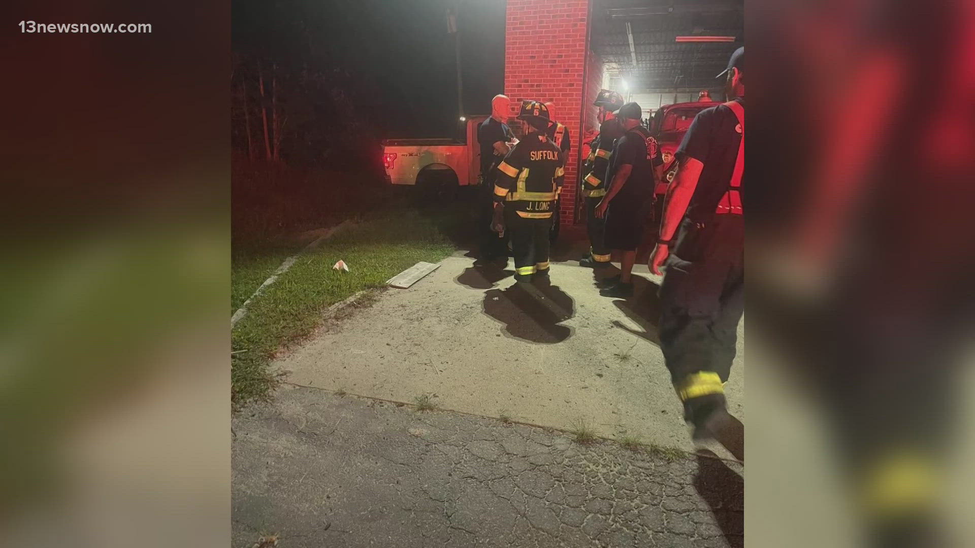 Firefighters respond after a truck hits a building in Suffolk