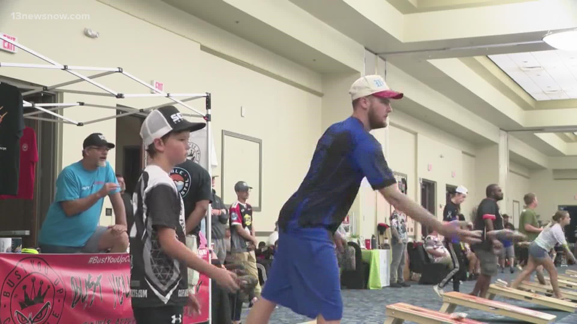 Players are tossing bean bags into holes to compete for thousands of dollars in prize money.